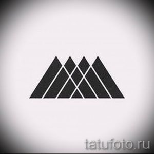 Фотография черно-белой татуировки с изображением трех пересекающихся треугольников. Простой и стильный рисунок для любителей минимализма.
