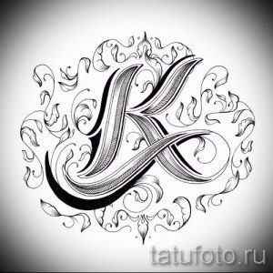 Черно-белое фото тату с буквой 'K', украшенной сложными растительными узорами. Классический и элегантный дизайн для ценителей каллиграфии.