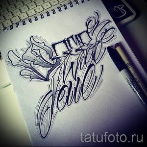 Черно-белый эскиз татуировки с надписью "Live Rebel", выполненной в оригинальном стиле с использованием плавных линий и декоративных элементов.