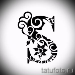 Черно-белый эскиз татуировки, сочетающий в себе букву "S" и силуэт женского лица, выполненный в стилизованном растительном орнаменте.