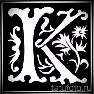 Чёрно-белый эскиз татуировки с изображением стилизованной буквы 'K', украшенной растительными элементами и звездой. Изящный и утонченный дизайн.