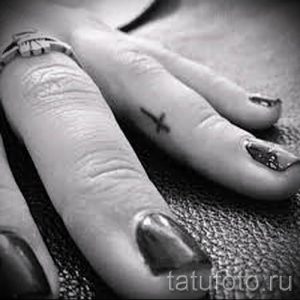Фотография достойной уже нанесенной на тело татуировки на пальце с крестом для выбора и отрисовывания своего эскиза - вариант