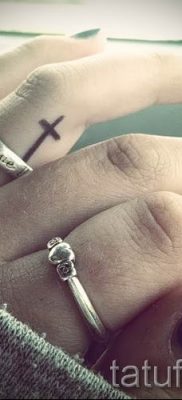 Фотография заслуживающей внимания уже нанесенной на тело татуировки на пальце с крестом для подбора и создания своего эскиза — пример