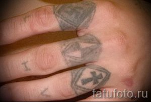 Фотография заслуживающей внимания уже нанесенной на тело татуировки на пальце с крестом для подбора и отрисовывания своего эскиза - вариант