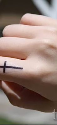 Фото заслуживающей внимания уже нанесенной на тело татуировки на пальце с крестом для подбора и создания своего эскиза — идея