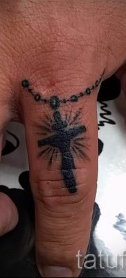 Фотография интересной уже нанесенной на тело татуировки на пальце с крестом для подбора и создания своего эскиза — идея