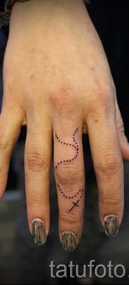 Фото необычной уже нанесенной на тело татуировки на пальце с крестом для выбора и отрисовывания своего эскиза — идея