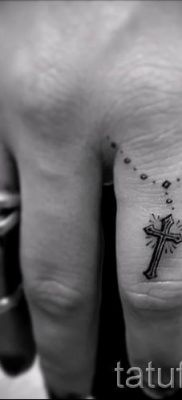 Фотография заслуживающей внимания уже нанесенной на тело тату на пальце с крестом для подбора и создания своего эскиза — пример