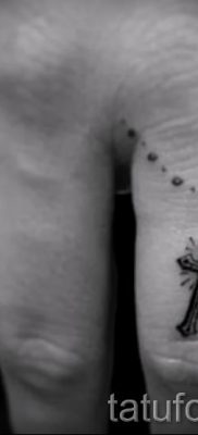 Фотография заслуживающей внимания уже нанесенной на тело татуировки на пальце с крестом для подбора и создания своего эскиза — пример