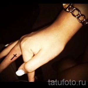 Фото крутой уже нанесенной на тело татуировки на пальце с крестом для подбора и создания своего рисунка - идея