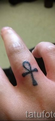 Фото достойной уже нанесенной на тело тату на пальце с крестом для выбора и создания своего рисунка — пример