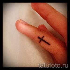 Фотография достойной существующей татуировки на пальце с крестом для выбора и создания своего эскиза - идея