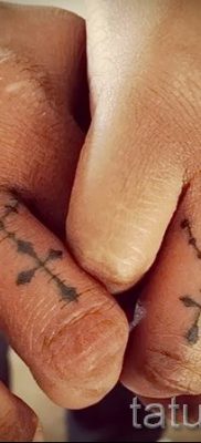 Фотография крутой уже нанесенной на тело тату на пальце с крестом для подбора и создания своего рисунка — вариант
