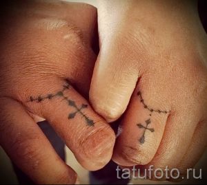 Фотография крутой уже нанесенной на тело тату на пальце с крестом для подбора и создания своего рисунка - вариант