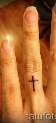 Фотография заслуживающей внимания уже нанесенной на тело тату на пальце с крестом для подбора и создания своего эскиза — пример