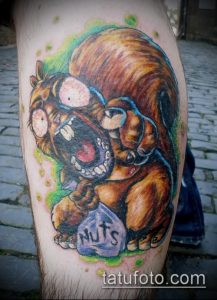 Фото тату разъяренной белки с открытым ртом и надписью 'Nuts'. Яркие цвета и мультяшный стиль.