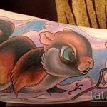 Фото тату белки с желудями на руке. Акварельный стиль, пастельные тона, реалистичное изображение.