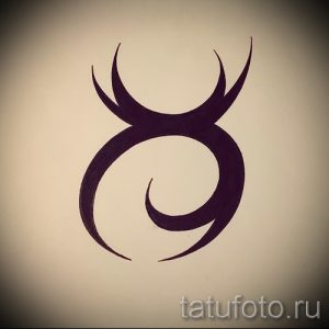 Простое черно-белое тату в виде стилизованной головы быка с рогами. Минималистичный дизайн подчеркивает силу и лаконичность.