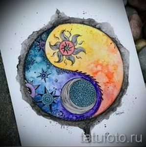 Фото акварельной татуировки Инь и Ян, в которой одна половина символа изображена как солнце, а другая – как луна. Яркий и красочный рисунок татуировки.