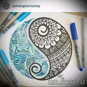 Фото тату Инь и Ян, выполненное в технике зентангл с использованием голубых и черных маркеров. Детализированный рисунок татуировки.