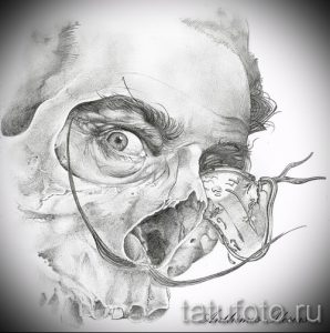 Фото эскиза татуировки с изображением лица, частично скрытого треснувшей маской. Реалистичный черно-белый рисунок.