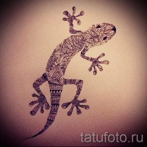 Фото тату геккона, выполненного в технике зентангл. Рисунок состоит из множества мелких узоров и орнаментов.