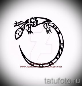 Фото тату геккона в стиле графика, выполненное в черном цвете. Рисунок состоит из четких линий и геометрических фигур.