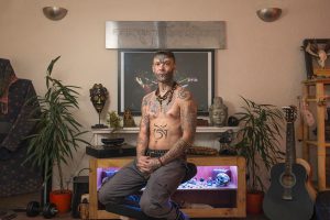 Фото тату: Мужчина с множеством татуировок, покрывающих большую часть тела, в этническом и религиозном стиле.