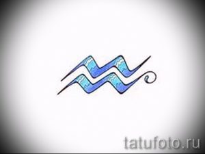 Фото тату: знак зодиака Водолей, выполненный в голубых и синих тонах, с использованием плавных линий и градиентов. Идеально для поклонников астрологии.