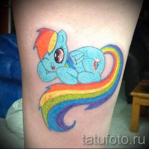 Фото тату Радуги Дэш из My Little Pony, летящей под радугой. Яркий, мультяшный стиль, красочные цвета. Идеально для поклонников мультфильма.