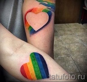Две татуировки на руках, изображающие сердца, окруженные радугой. Парный рисунок татуировки, символизирующий любовь.