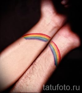 Фото парных тату радуги на запястьях. Минималистичный дизайн, яркие цвета, символ любви и единства.