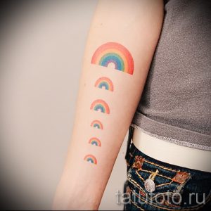Фото тату нескольких маленьких радуг на руке. Минималистичный дизайн, яркие цвета, подходит для девушек и любителей простых татуировок.