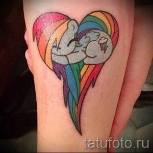 Фото тату: яркое тату в виде сердца, внутри которого обнимаются две милые пони, выполненное в стиле мультфильма.