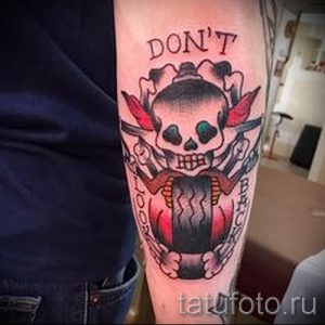 Фото тату: классическая олдскульная татуировка с изображением черепа, пронзенного двумя кинжалами, и надписью 'Don't Look Back'.