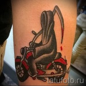 Фото тату жнеца на мотоцикле в стиле традишнл. Черно-серый рисунок с четкими контурами и яркими акцентами.
