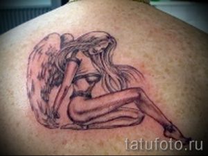 Фото тату сидящего ангела на спине. Изящный рисунок татуировки, выполненный в черно-серых тонах, символизирующий нежность и духовность.