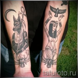 Фото тату на предплечьях: Анубис с головой шакала и богиня Исида, выполненные в черно-серых тонах с детальной проработкой.