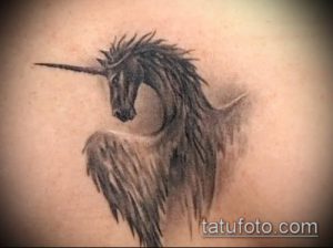 Фото тату единорога в стиле blackwork. Рисунок выполнен полностью черным цветом, с акцентом на текстуру и детализацию, расположен на руке.