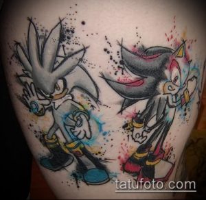Фото тату персонажей Соника и Шэдоу из игры Sonic the Hedgehog на руке. Яркие цвета, динамичная композиция и брызги краски. Эскиз тату для фанатов игр.