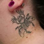 Фото небольшой татуировки жука-носорога на шее. Черно-серый рисунок с детальной проработкой рогов и крыльев.