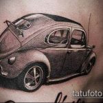 Фото реалистичной татуировки автомобиля Volkswagen Beetle на боку. Детализированный рисунок с использованием теней и световых акцентов.