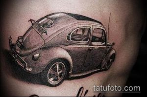 Фото реалистичной татуировки автомобиля Volkswagen Beetle на боку. Детализированный рисунок с использованием теней и световых акцентов.