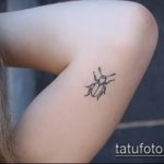 Фото минималистичной татуировки жука на ноге. Простой и элегантный рисунок татуировки в технике лайнарт.
