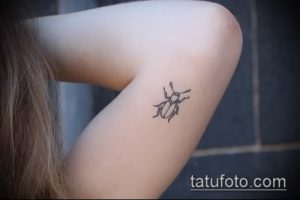 Фото минималистичной татуировки жука на ноге. Простой и элегантный рисунок татуировки в технике лайнарт.