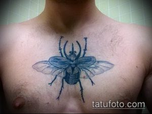 Фото тату жука-носорога на груди. Черно-белый рисунок с минималистичным дизайном.