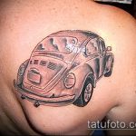 Фото тату старого автомобиля Volkswagen Beetle на плече. Реалистичный стиль, черно-белая татуировка, детализированный рисунок.