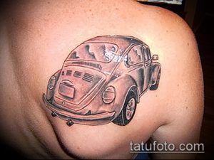 Фото тату старого автомобиля Volkswagen Beetle на плече. Реалистичный стиль, черно-белая татуировка, детализированный рисунок.