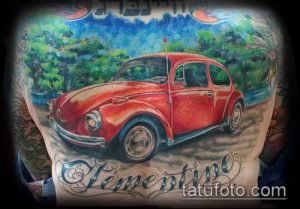 Фото тату: красный Volkswagen Beetle на фоне пейзажа, выполненный в ярких цветах. Детализированный рисунок на спине.