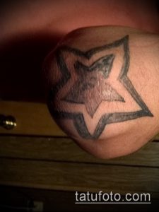 Фото минималистичной татуировки на локте в виде звезды, выполненной в черно-серых тонах. Простой и элегантный дизайн.